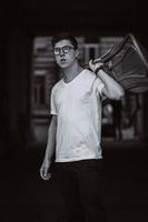 portrait of men standing with chair in white t-shirt and sunglasses in the street photo