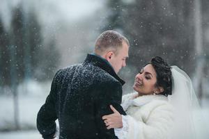 Bride and groom walking on the European city in the snow photo