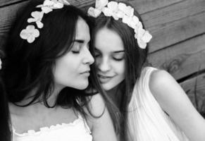 Three charming girls  near a wooden house photo