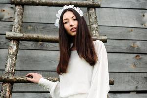 Lovely girl near a wooden house photo