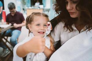 Young mom eating cake with smiling kid on the street photo