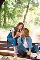 dos hermosas mujeres jóvenes descansando en un banco foto