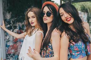 tres hermosas chicas jóvenes en la parada de autobús foto