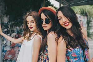tres hermosas chicas jóvenes en la parada de autobús foto