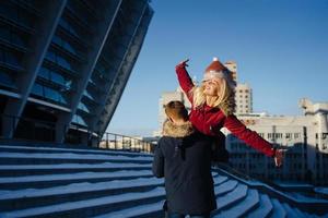 Guy on the shoulder is carrying the girl, winter outdoors. photo