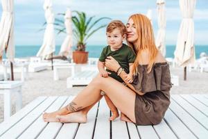 mamá y su pequeño hijo en la playa, de vacaciones foto