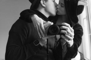 man and woman in black clothes kissing photo