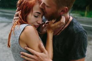 beautiful couple hugging in the rain photo