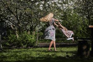 mother twist daughter in the garden photo