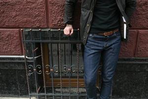 Male model in jeans on the background of a red wall photo