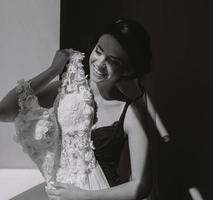 bride sitting holds wedding dress photo