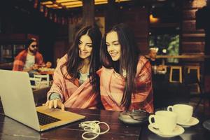 dos chicas viendo algo en la computadora portátil foto