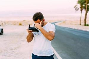 Guy controls drone with remote control photo