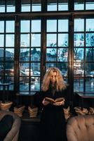 Woman reading a book on the background of window photo