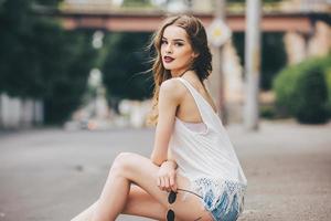 pretty girl sitting in a city street photo