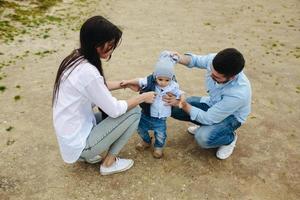 familia joven feliz con un niño pequeño en la naturaleza foto