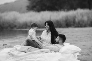 Happy young family relaxing together on the lake photo