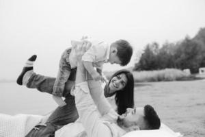 familia joven feliz relajándose juntos en el lago foto