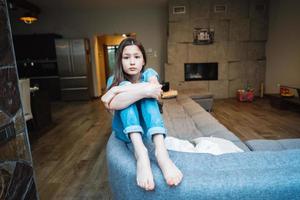 Positive smiling teenage girl on a couch. photo