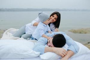 Happy young family relaxing together on the lake photo