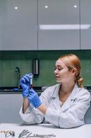 Female medical or scientific researcher looking at a test tube in a laboratory. photo