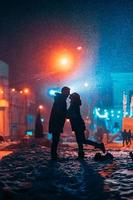 Young adult couple in each other's arms on snow covered street. photo