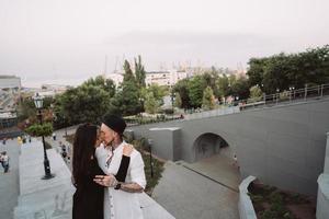 A young, sexy couple of lovers pose for a camera on the streets photo