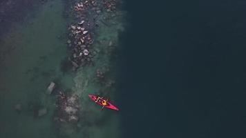 two athletic man floats on a red boat in river photo