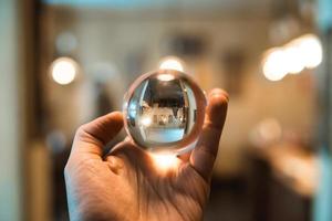 man holding a glass ball indoors photo