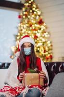 Girl holding a Christmas present on New Years Eve. photo