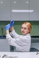 investigadora médica o científica femenina mirando un tubo de ensayo en un laboratorio. foto