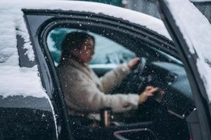 Attractive woman driver nsitting behind the steering wheel in her car photo