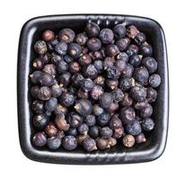 dried juniper berries in black bowl isolated photo