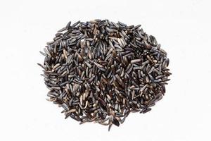 pile of whole-grain niger seeds on gray photo