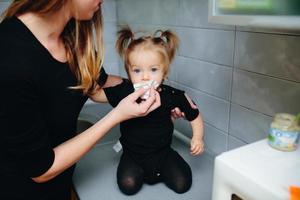 Mother with daughter standing in kitchen photo