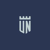 monograma del logotipo de la ONU con castillo de fortaleza y diseño de estilo de escudo vector