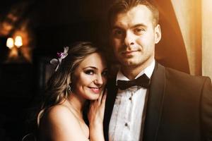 The bride and groom in a cozy house, photo taken with natural light from the window.