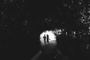 couple walking through the tunnel of trees photo