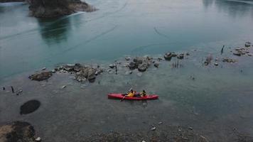 two athletic man floats on a red boat in river photo