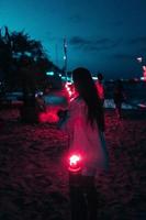 Young woman with torchlight on the beach at night photo