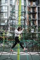 Young woman having fun on the rope pyramid photo