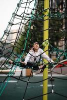 Young woman having fun on the rope pyramid photo