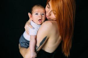 joven madre mujer sosteniendo a su hijo bebé foto