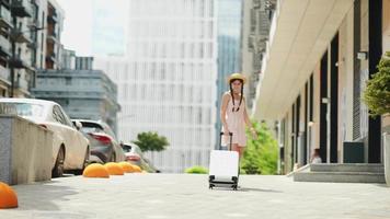 Young woman explores city while carrying luggage video
