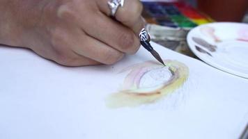Frau malt mit Wasserfarben auf Papier video