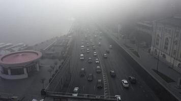 los coches viajan por una carretera neblinosa junto a un río en Kyiv, ucrania