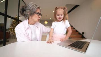 menina usando computador em casa com a família video