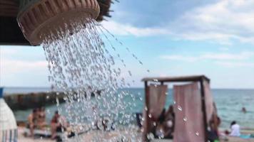 Water streams from outdoor shower by a beach video