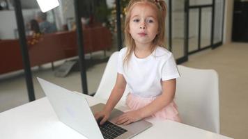 Little girl using computer at home with family video