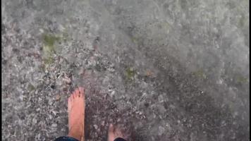 nackte Füße tauchen an einem Strand ins Meerwasser ein video